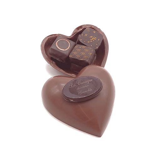 bonbonniÃ¨re en forme de cÅ“ur en chocolat avec un assortiment de chocolat Ã  l'interieur.